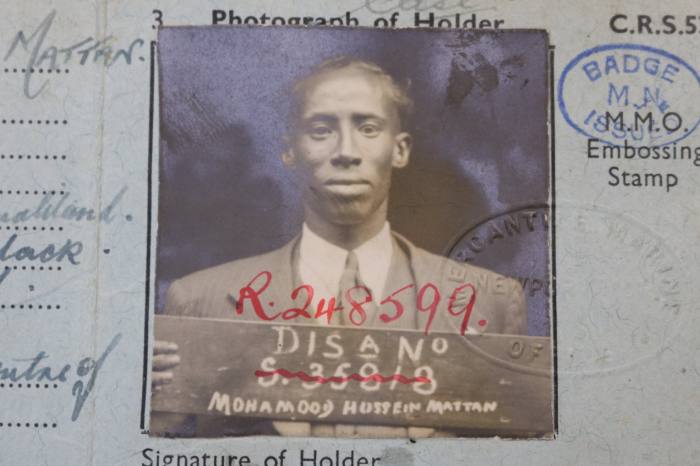 Passport photo of a man on a blue borm