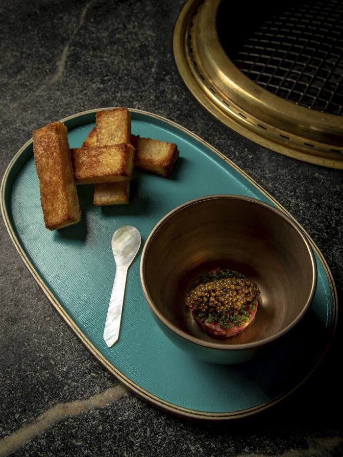 A bowl of Cote’s take on steak and eggs – filet mignon tartare topped with caviar in a bowl, and served with slices of milk toast
