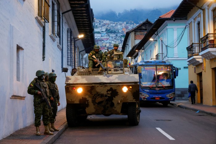 An armoured personnel carrier drives down a city street