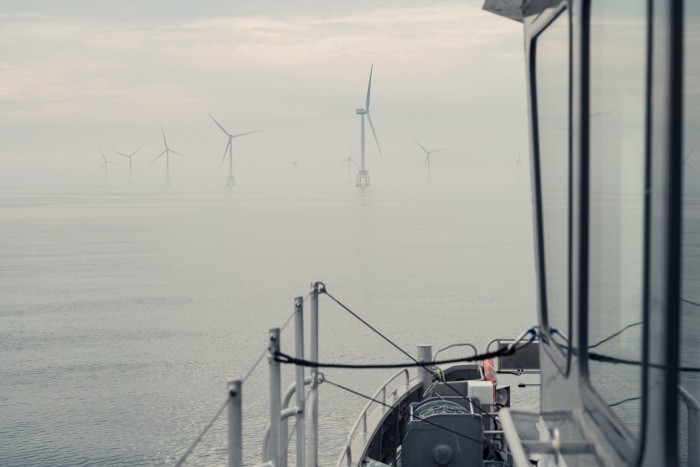 Wind turbines in the sea, seen from a boat on a misty day