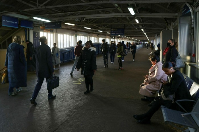 Commuters pass along a walkway at Clapham Junction railway station in London