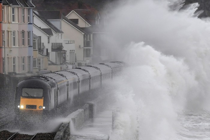 Large waves crash over a train as it passes through Dawlish in southwest Britain