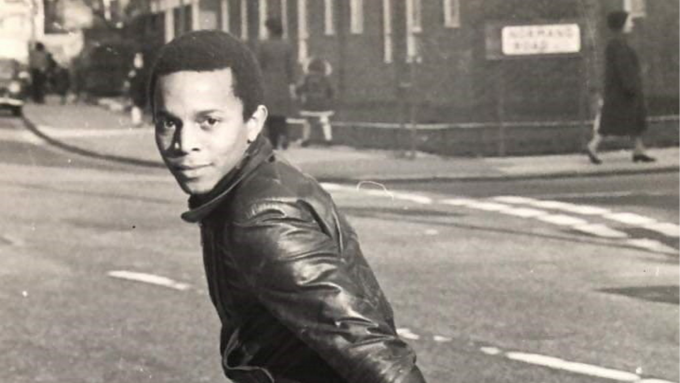 A young black man turns back towards the camera