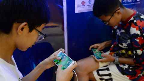 Jongens spelen het spel 'Honor of Kings' van Tencent tijdens een evenement in een winkelcentrum in de provincie Hebei, China