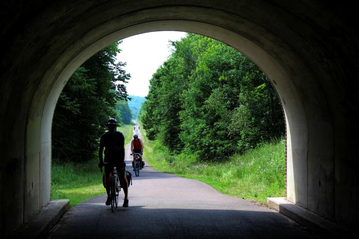 Cycling through an arch with green landscape in the background