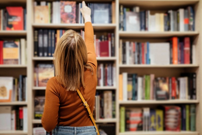 Girl points at book on bookstore shelf
