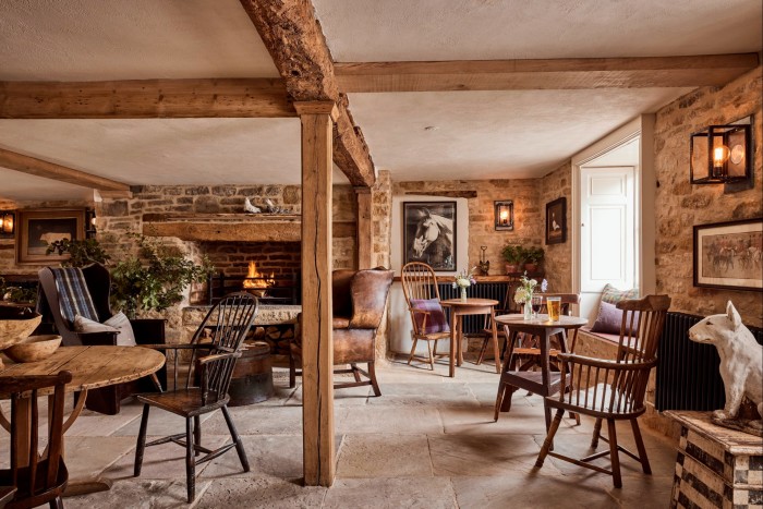 Ghế và bàn dưới mái nhà có xà ở The Parlour, một trong những khu vực ăn uống của The Fox at Oddington