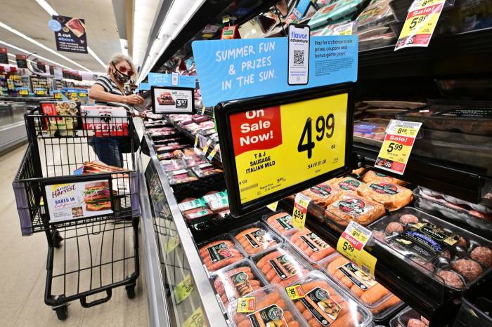 A woman checks an item from the meat department while grocery shopping at a supermarket in Alhambra, California