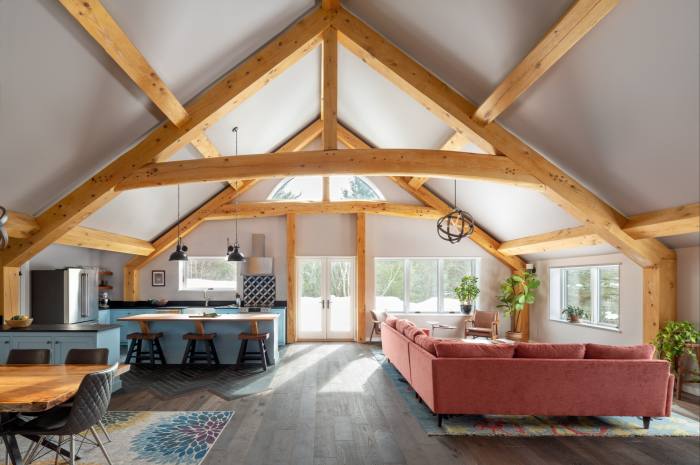 A room with blonde A-frame timbers and an open-plan design