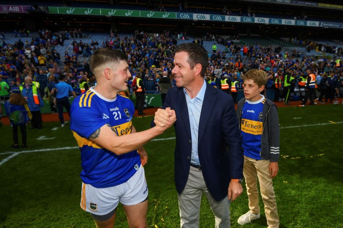 Declan Kelly, right, who grew up in County Tipperary, shakes hands with Willie Connors after a hurling match between Tipperary and Kilkenny in Dublin in August 2019 