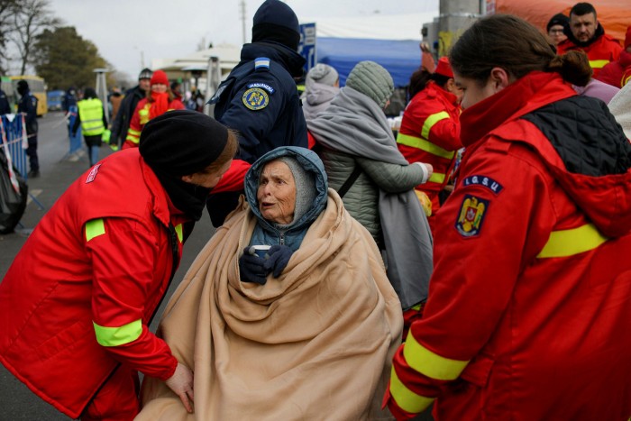 Emergency workers talk to 90-year-old Katia, a refugee fleeing the conflict from neighbouring Ukraine at Siret, Romania