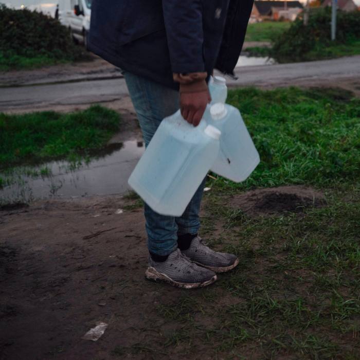 Man holding two containers of water