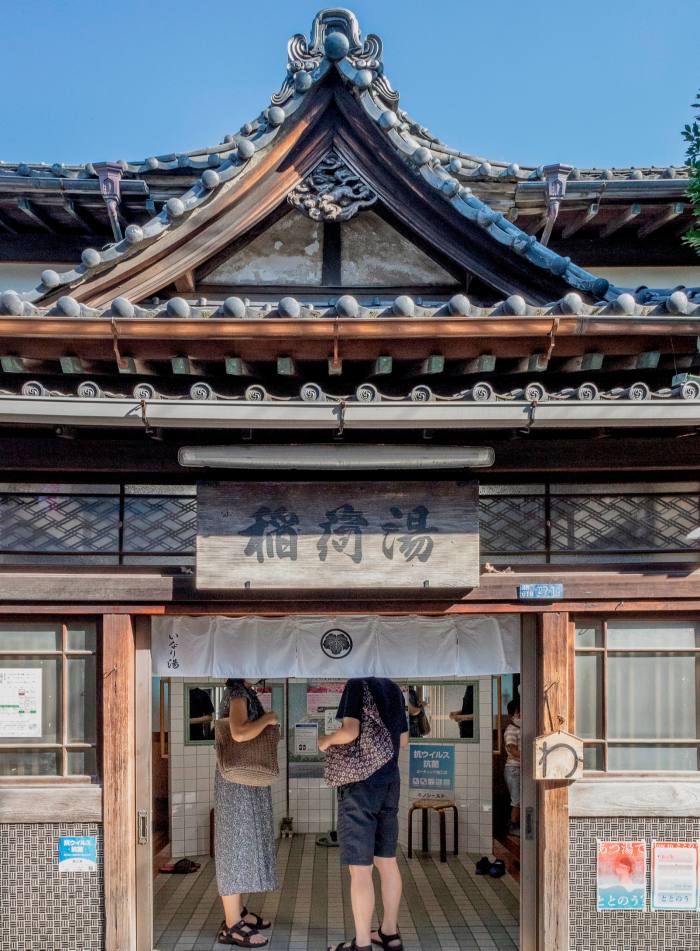 Customers at the temple-style entrance to the Inari-yu sento