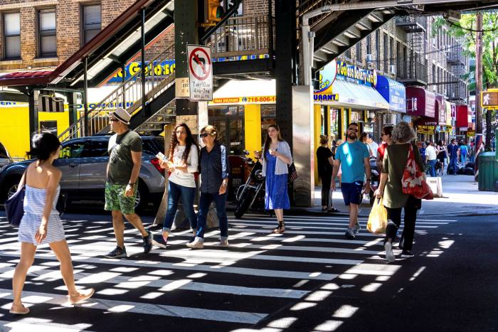 A pedestrian crossing is crowded with queens