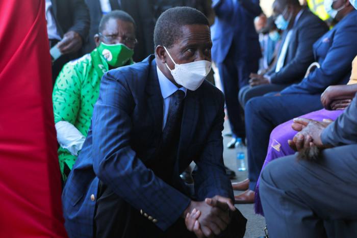 The President of Zambia, Edgar Lungu, squatted down while talking to people when the airport terminal opened