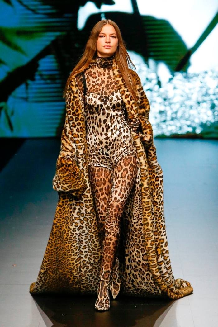 A model wears a leopard print bodysuit with a matching long coat