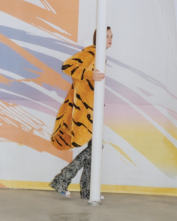Louis Vuitton satin animal-print asymmetric coat, £6,500, and flared trousers, £4,200. Comme Si Egyptian-cotton socks, £28. Vintage shoes, handpainted by John Hurley. Artwork: Mesh Installation, 2022, by Márton Nemes