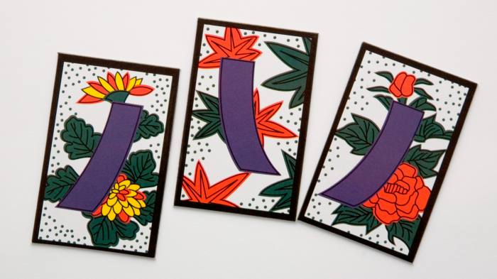 Three playing cards feature bold colourful designs