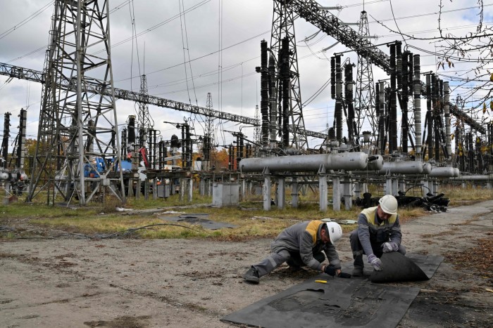 Workers repair equipment after a Russian strike on Ukrainian power lines