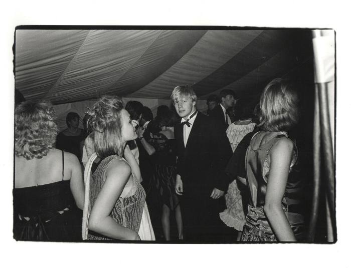 A young Boris Johnson in a dinner suit at a party in a marquee (and surrounded by young ladies) 