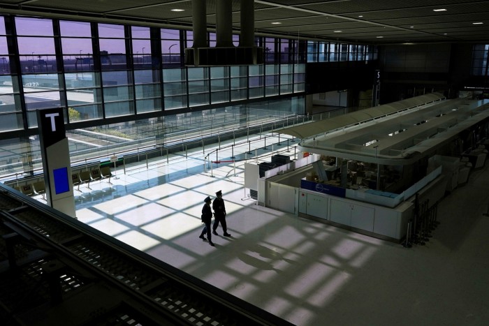 Police patrol an empty check-in area at Narita airport in Japan
