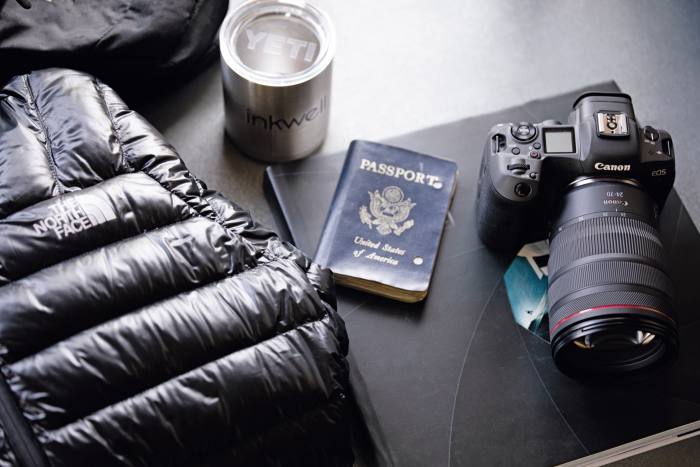 His Canon EOS 5D camera next to his well-worn passport 