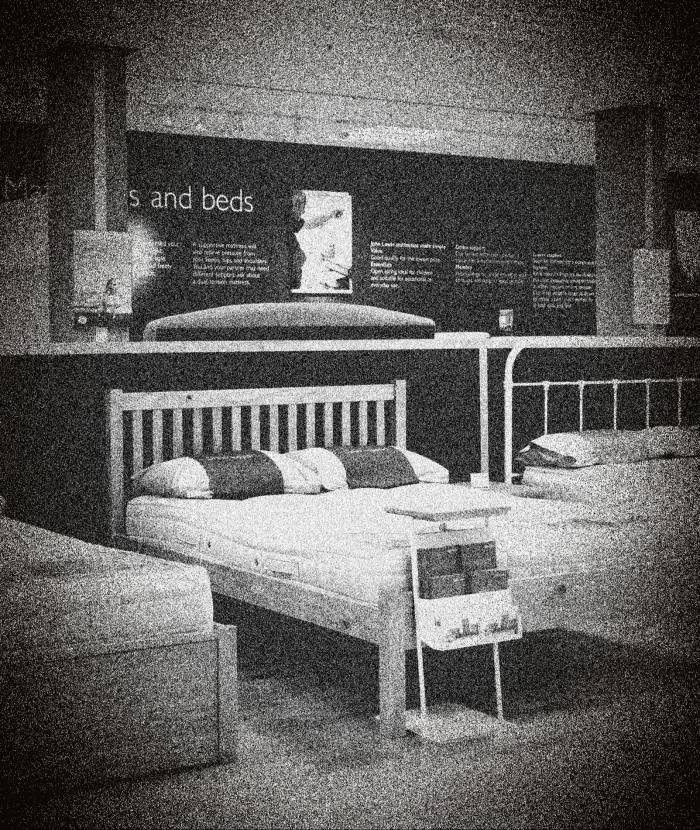 A black-and-white shot of beds for sale inside a John Lewis store