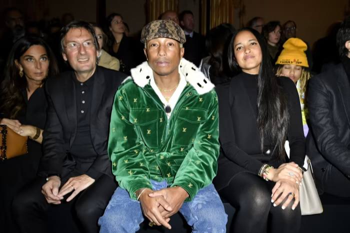 Pharrell Williams sits next to Pietro Beccari during the Louis Vuitton Womenswear Fall-Winter 2023 fashion show in March