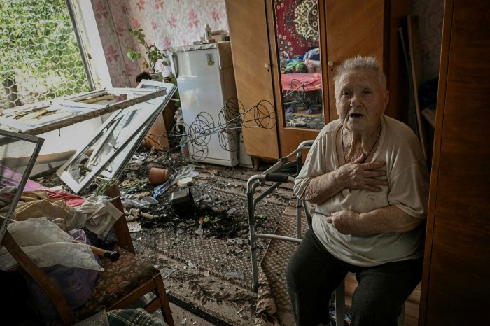 A woman sits in her damaged house in the eastern city of Soledar as artillery battles continue in the Donbas