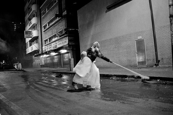 Une femme balayant la rue