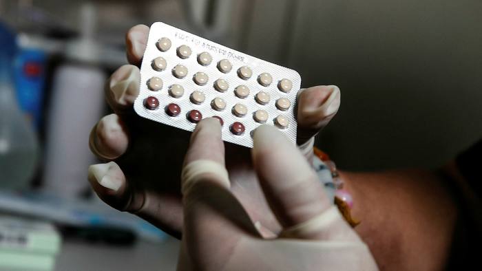 A Filipino health worker holds birth control pills at a women’s health clinic in Manila