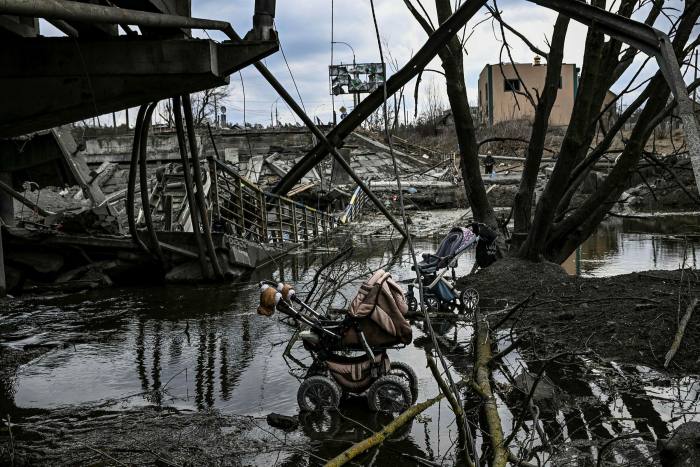 Abandoned strollers are pictured under a destroyed bridge as people flee the city of Irpin, west of Kyiv, on March 7, 2022