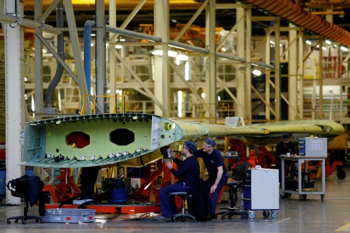 Employees work on a section of Airbus A320 wing inside the assembly plant