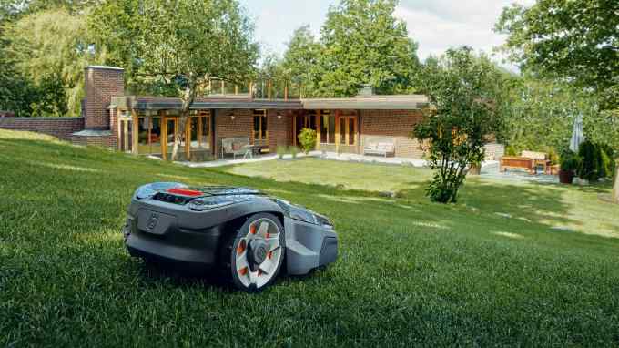 The Husqvarna Automower 415 sits on a well-trimmed lawn