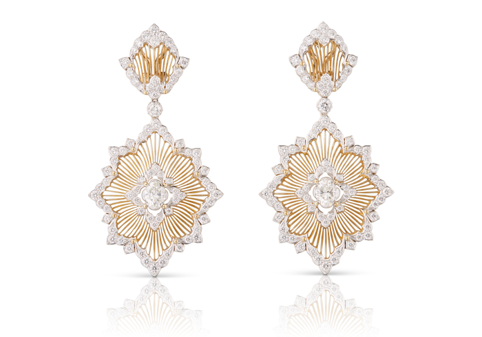 A pair of earrings made from gold strands in the shape of broches with diamond edging