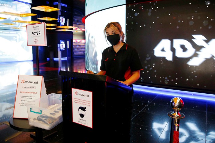 A Cineworld employee wears a mask at the chain’s Leicester Square cinema in London