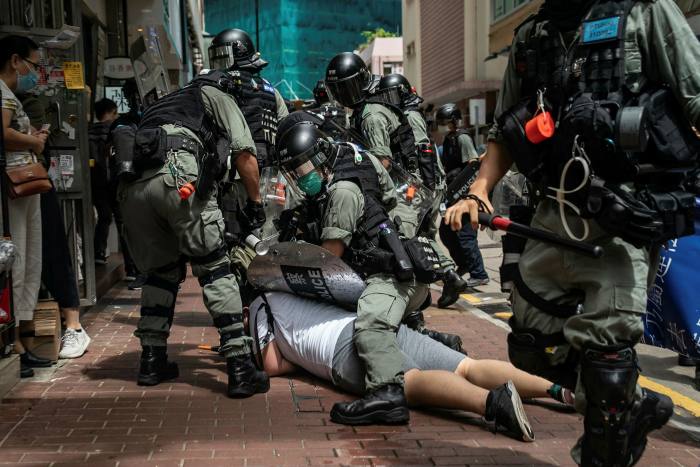 Die polisie arresteer 'n betoger teen Hongkong se nasionale veiligheidswet wat deur Beijing ingestel is.  Die wet is gebruik om politieke opposisie in die gebied te onderdruk
