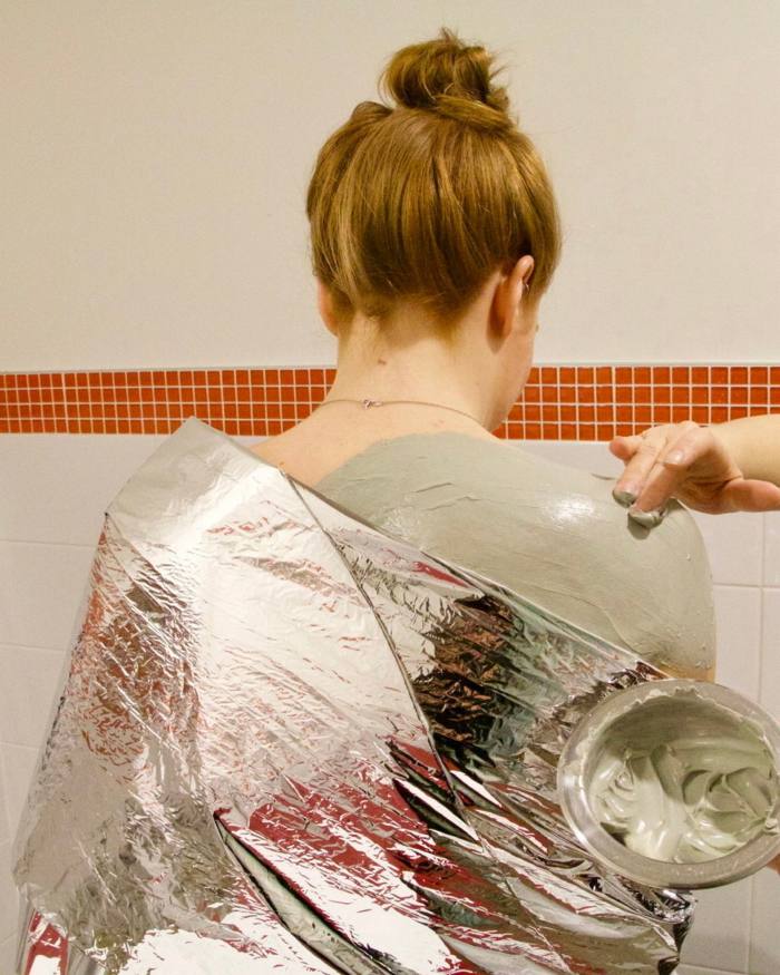 Una mujer recibe un tratamiento de lodo corporal en Body Blitz Spa