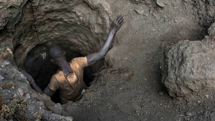 A miner descends into a copper and cobalt mine — a hole in the ground — in the Democratic Republic of Congo