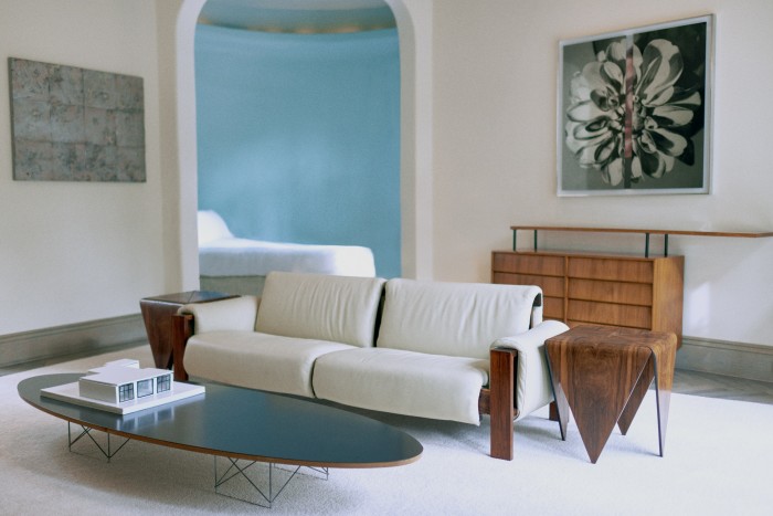 A living room space in Chow’s residence featuring a Joaquim Tenreiro sofa, Jorge Zalszupin side tables bought from Brazilian design dealer Ulysses de Santi, and works by artist Kathryn Andrews