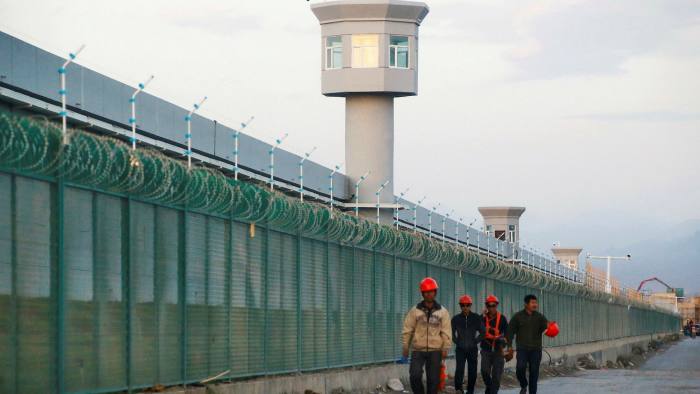 Workers outside the perimeter fence of what is officially an education centre in Xinjiang, China