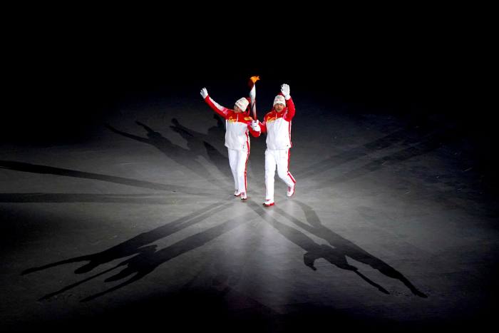 Dinigeer Yilamujiang and Zhao Jiawen carry the Olympic torch during the opening ceremony