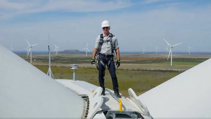 Amazon founder Jeff Bezos standing on wind turbine