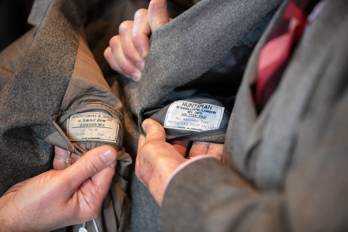 Anthony Peck comparing the Huntsman label on his suit with the original label in his father’s suit