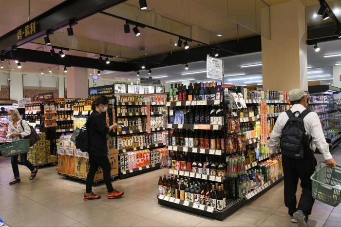 Clientes en la sección de bebidas alcohólicas de un supermercado en Tokio, Japón