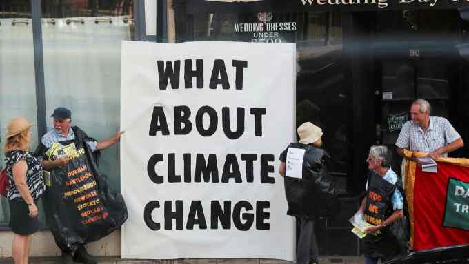 Protestors hold a sign saying ‘What about climate change’