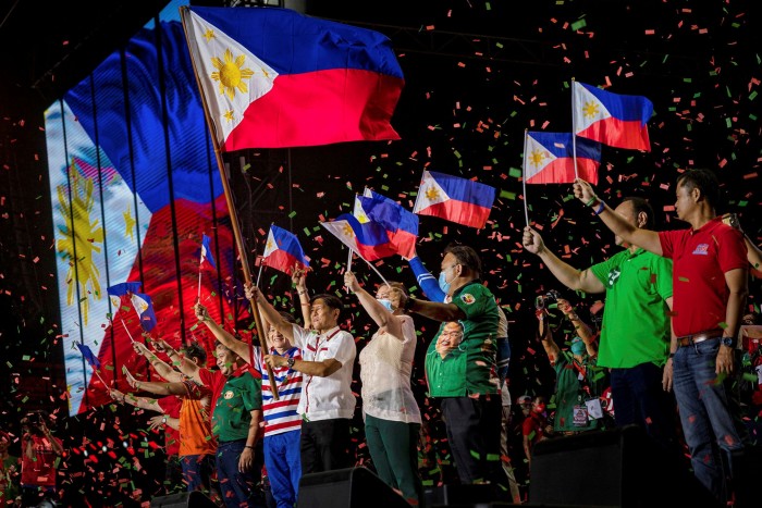 Ferdinand Marcos Jr and running mate Sara Duterte wave Philippine flags during a campaign rally on Saturday
