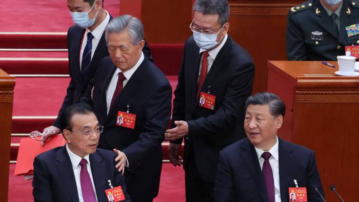 Former leader Hu Jintao, center left, is escorted out of Beijing’s Great Hall 