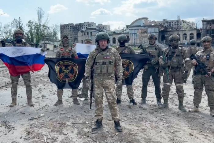     a company connected to the head of the Wagner Russian mercenary group, Yevgeny Prigozhin - Yevgeny Prigozhin shows the Russian national flag in front of the soldiers holding the flags of the Wagner group in Bakhmut,