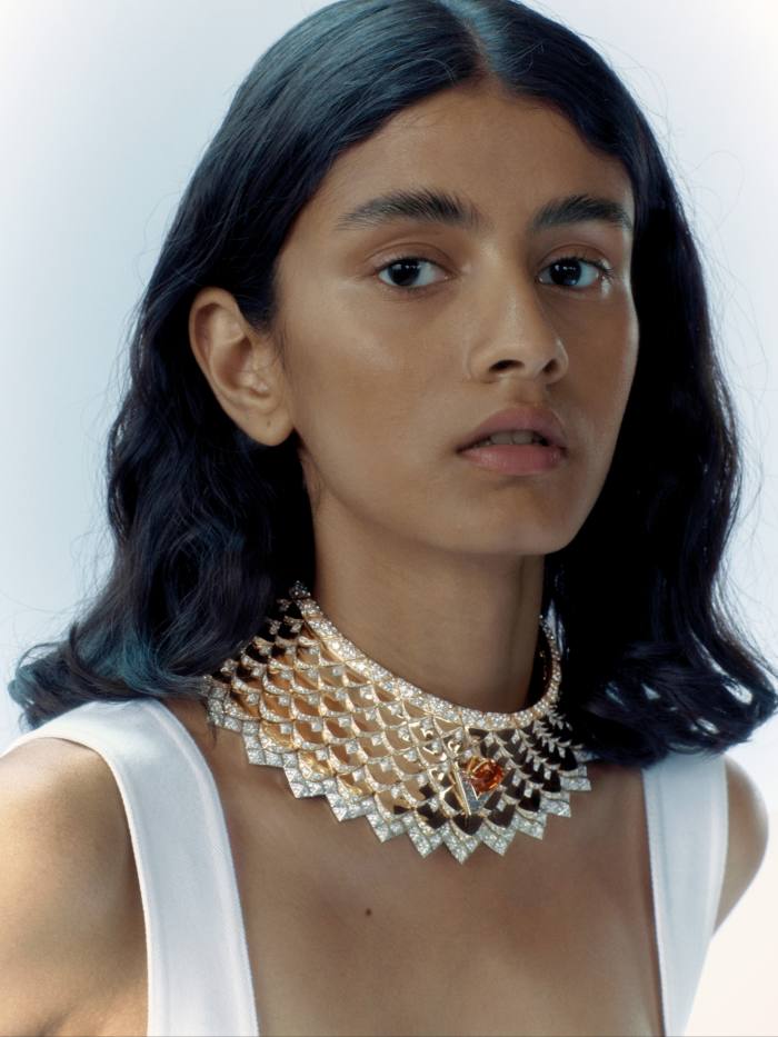 A young woman wearing a large piece of bejeweled necklace